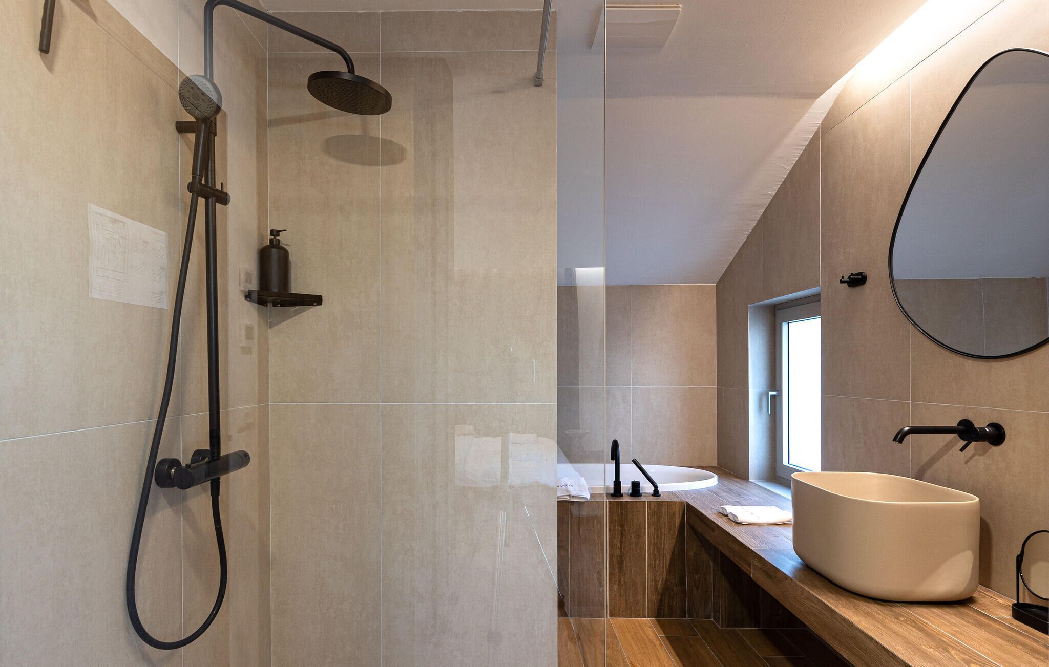 Un bagno moderno con doccia, lavandino e specchio.