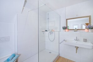 Douche, sèche-cheveux, peignoirs, serviettes fournies