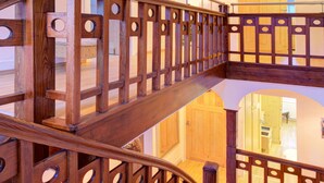 Una scala in legno con ringhiera, che conduce a un piano superiore.