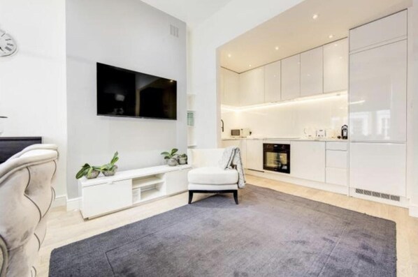 Relax in a spacious living area with a flat-screen TV, seating area, and kitchenette.
