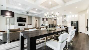 Een ruime keuken met een groot eiland, moderne apparatuur en een hoog plafond met zichtbare balken.