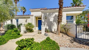 A two-story house with a white exterior, a blue door, and a tiled roof. - Pool & Hot Tub Access: La Quinta Vacation Home (La Quinta)