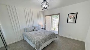 A bedroom with a bed, a ceiling light, a window, and a door. - Relaxing Golf Course, Pool, remodeled sleeps 6 (La Quinta)