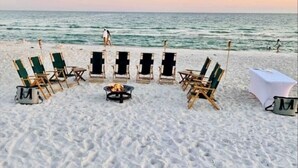A beach setup with lounge chairs and a table, arranged for an outdoor event. - Luxury Beach House: Rooftop Jacuzzi & Family Fun (Inlet Beach)