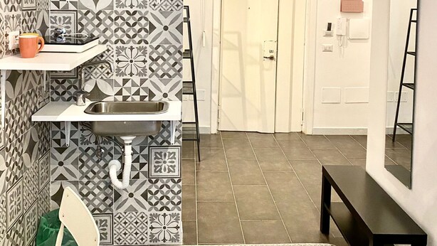 A modern bathroom with patterned tiles, a sink, a chair, and a bench. - APT. - Studio apartment in the historic center of Naples (Napoli)