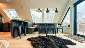 Une cuisine moderne avec un coin repas, de grandes fenêtres et un tapis noir à poils longs.