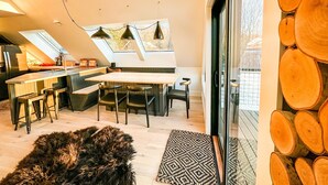 Une cuisine moderne dotée d’un îlot central, de chaises noires et de luminaires suspendus.
