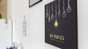 Una pared con una cita motivacional e ilustraciones de bombillas.