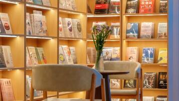 A bookshelf with books and a vase with flowers.