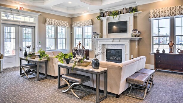 A spacious living room with a fireplace, comfortable seating, and a television.