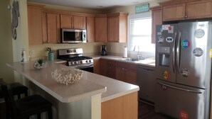 A modern kitchen with wooden cabinets, stainless steel appliances, and a central island.
