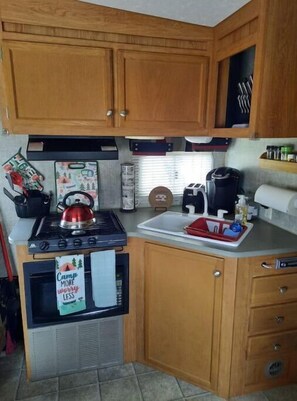 Kitchen area with a stove, sink, and coffee maker, perfect for preparing meals.