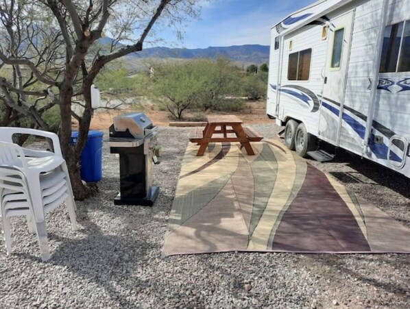 Enjoy a picnic under the shade of a tree, surrounded by a scenic view of rolling hills.