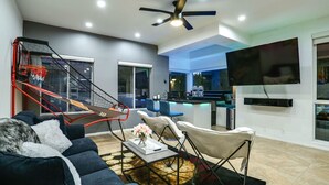 Un salon moderne avec un canapé, une table basse et un téléviseur fixé au mur.