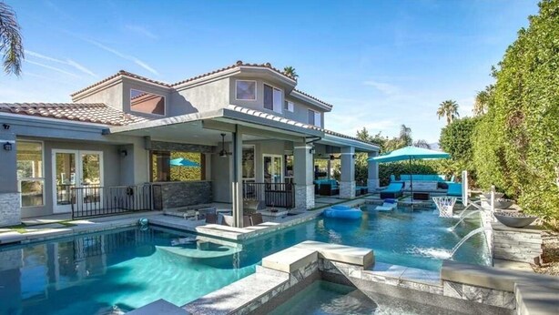 Une maison moderne dotée d’une piscine, d’un espace salon extérieur et d’un patio couvert.
