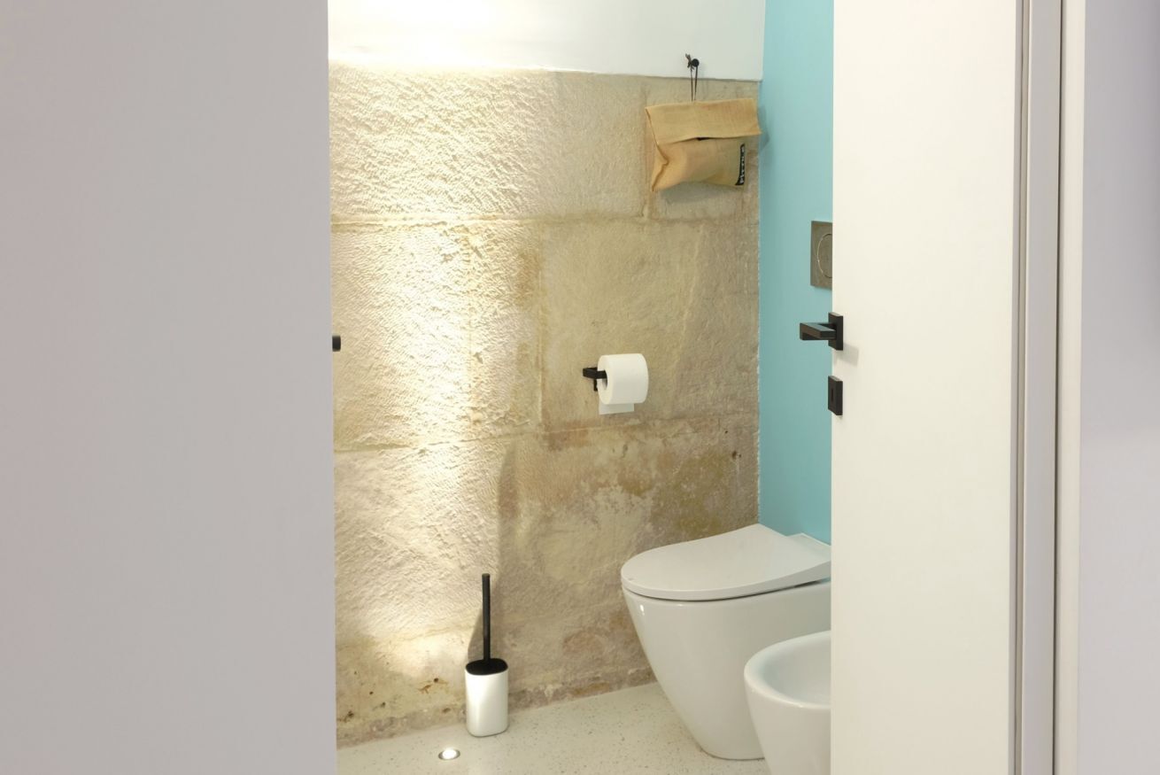 Une salle de bain équipée d’un WC, d’un bidet, d’un porte-serviettes et d’un support à papier toilette.
