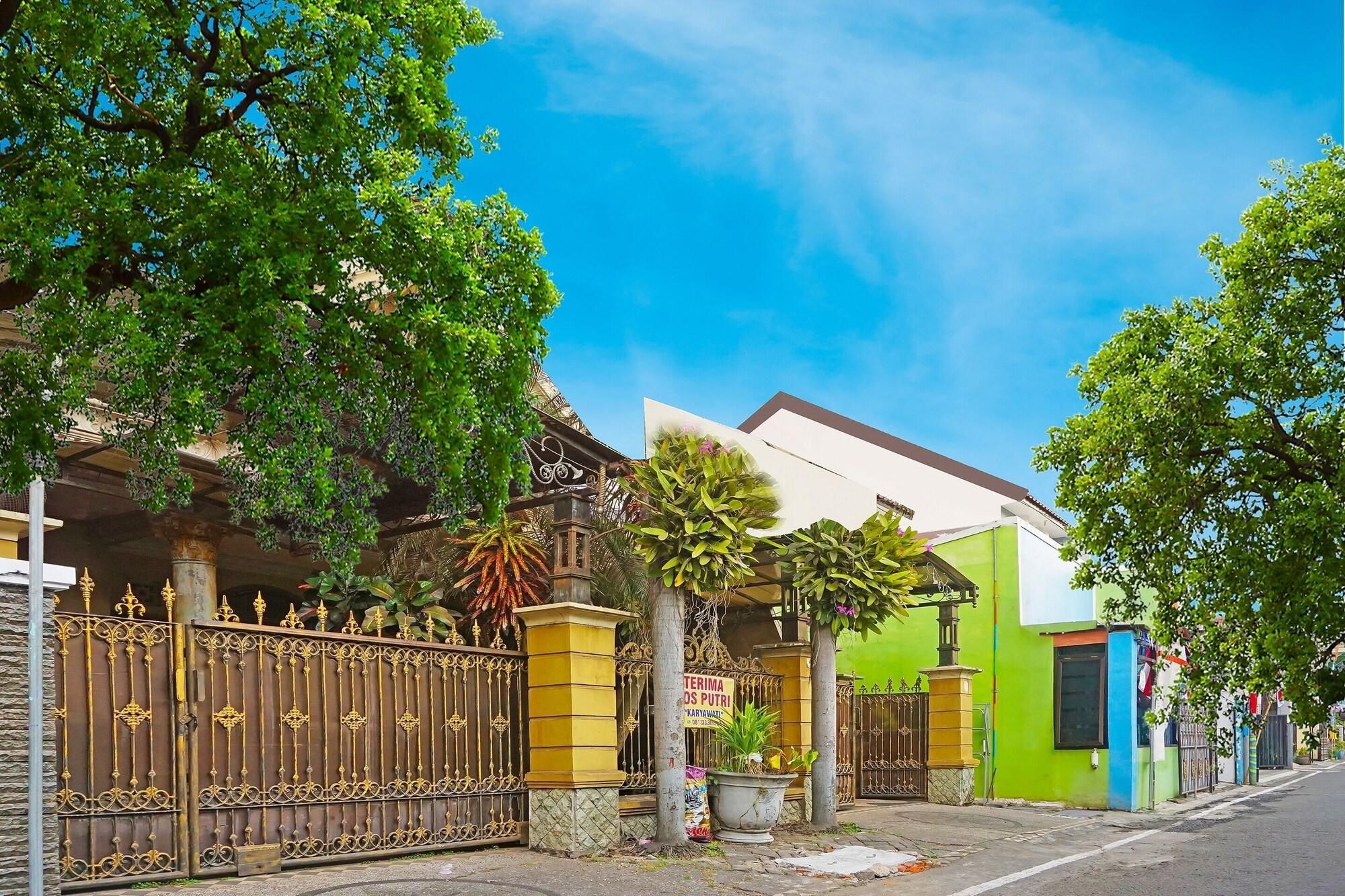 A residential area with a gated entrance, a building with a sign, and a street.