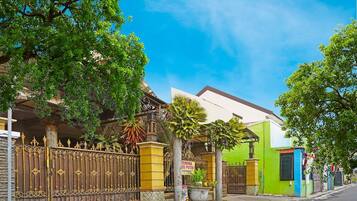 A residential area with a gated entrance, a building with a sign, and a street.