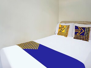 A bed with white bedding and two decorative pillows with geometric patterns. - Spot On 91551 Gwen Syariah Homestay (Tanjung Pinang)