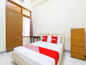 Une chambre avec un lit simple, une armoire en bois, une table de chevet et une fenêtre avec un rideau.