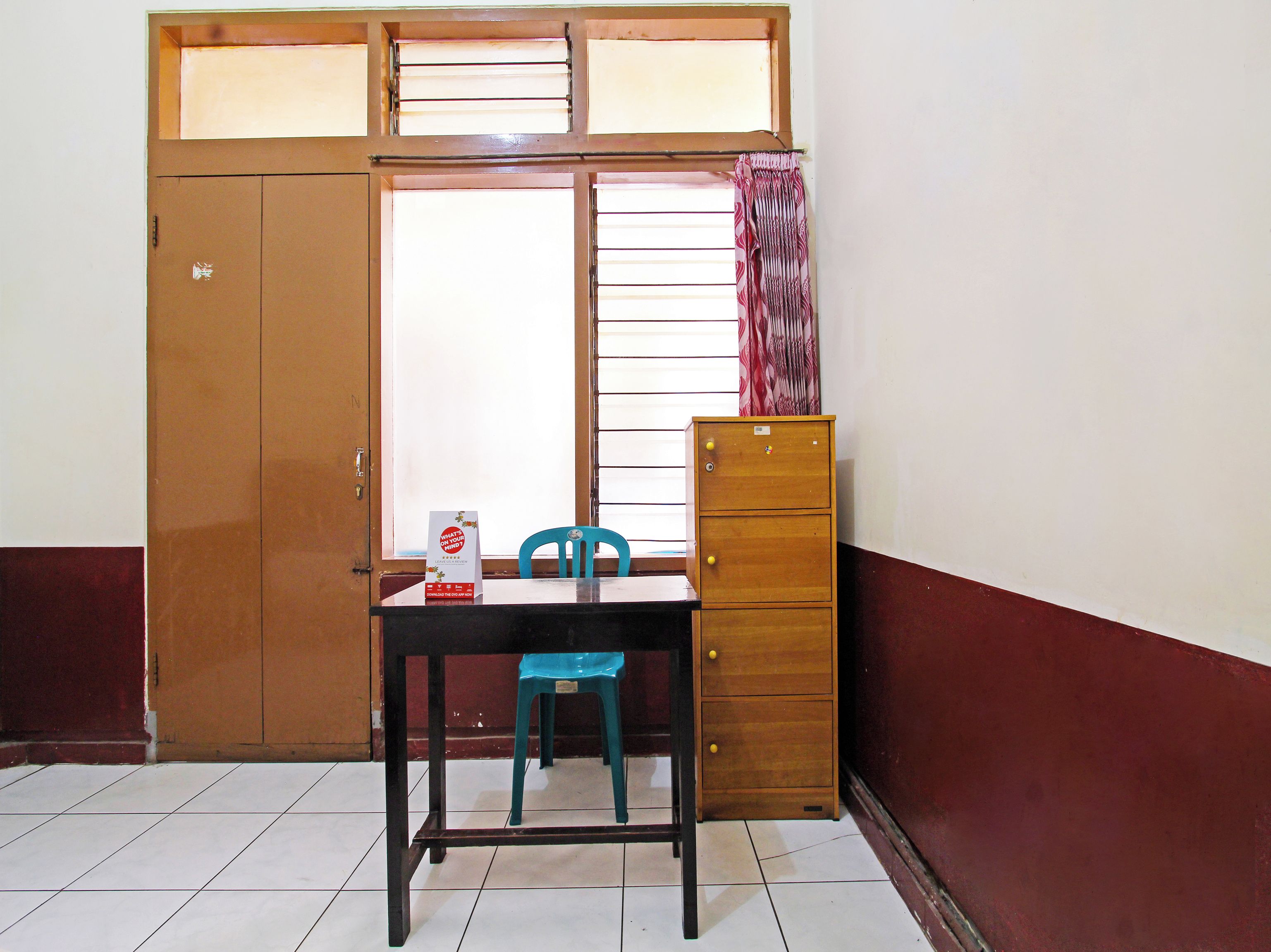 Una habitación con un armario de madera, un escritorio con silla y una ventana con persianas.