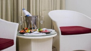 A dining table with a bottle of champagne, a glass, and a plate of food. - The Lokal Hotel Phuket (Patong)