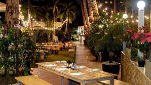 An outdoor dining area with string lights, tables, and potted plants. - The Lokal Hotel Phuket (Patong)