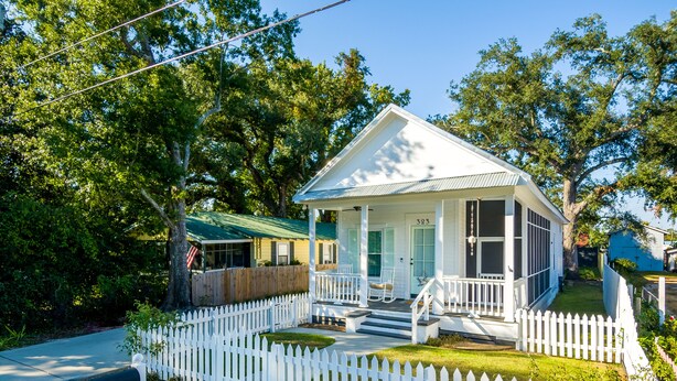 A single-story house with a porch, a mailbox, and a white picket fence. - Bay St. Louis Cottage located less than a mile from Downtown!!! (Bay St. Louis)
