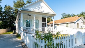A white two-story house with a porch, a number 323 sign, and a white picket fence. - Bay St. Louis Cottage located less than a mile from Downtown!!! (Bay St. Louis)