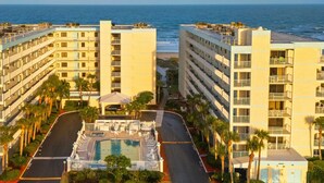 Un hotel de varios pisos con piscina y vista al océano.