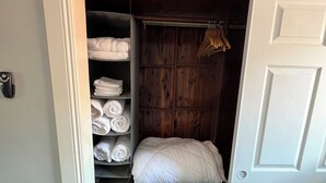Un dressing avec des étagères pour ranger les serviettes pliées et des barres pour suspendre les vêtements.