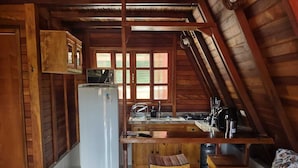 Una cucina compatta con frigorifero, lavello e fornelli.