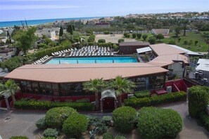 Ein Hotel mit Pool, Liegestühlen und Meerblick.