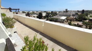 Zona residenziale con vista sul mare, caratterizzata da edifici moderni, un pergolato e qualche area verde.