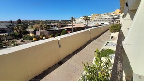 Un balcone con vista su una zona residenziale, con edifici e palme.