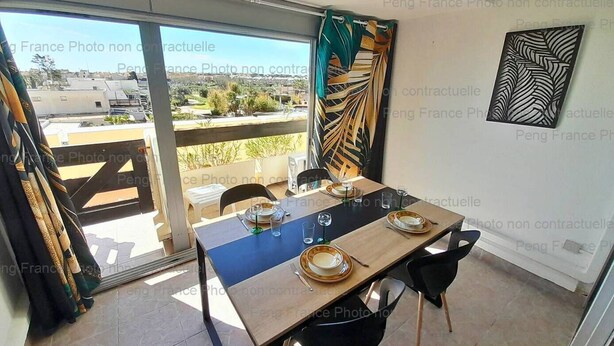 Zona pranzo con tavolo imbandito per due, vista sull'esterno e pannello decorativo a parete.