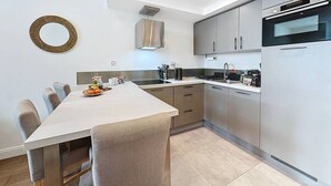 Una cocina moderna con una isla central, electrodomésticos de acero inoxidable y un diseño minimalista.