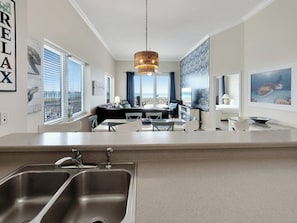 Eine moderne Küche mit doppeltem Spülbecken, Essbereich und Meerblick.