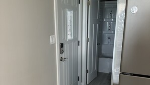 A kitchen with a stainless steel refrigerator, a trash can, and a door leading to a pantry. - Lake/Beach Getaway (Remodeled) (Round Lake Beach)