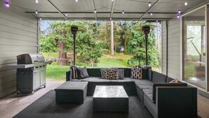 An outdoor patio with a grill, seating area, and string lights. - Large Open Home - Gourmet Kitchen - Pool Table (Portland)