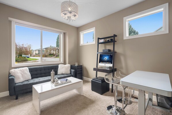 A modern living room with a sofa, coffee table, and a TV on a stand.