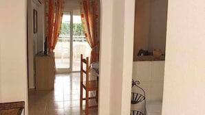 A hallway with an arched doorway leading to a balcony with orange curtains. - Apartment 150 meters from the beach, 500 meters from Denia (Denia)