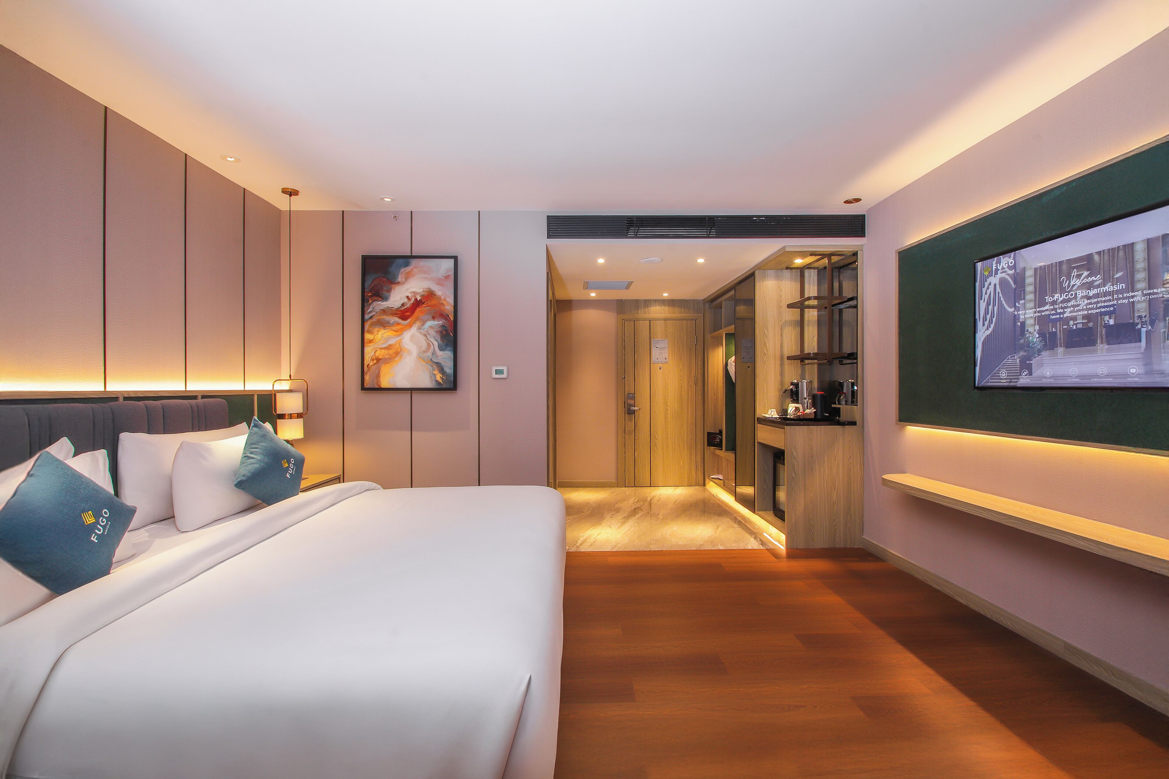 A modern hotel room with a large bed, a TV mounted on the wall, and a wooden cabinet.