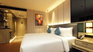 Una habitación de hotel moderna con una cama grande, una mesita de noche y un televisor montado en la pared.