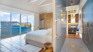 A bedroom with a large window overlooking a scenic view, a bathroom with a modern sink and shower, and a spacious balcony. - Jasper -20% Low Season Promo | Ocean Front - Located in  Stunning Simpson Bay with Private Pool (Marigot)