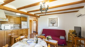 A dining area with wooden furniture, a chandelier, and a red sofa. - CARREBAIX II - Wonderful apartment with free WiFi. (Orba)