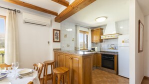 Una cucina con mobili in legno, un piano di lavoro in granito e un'area pranzo con tavolo apparecchiato per due.