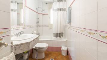 Un baño con lavamanos, inodoro y bañera.