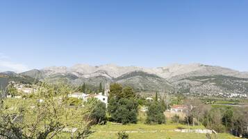 Un paisaje montañoso con edificios en primer plano y cielo despejado.