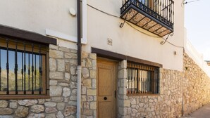 A stone facade building with a wooden door, barred windows, and a balcony with ornate metal railings. - CARREBAIX V - Cosy studio with free WiFi. (Orba)